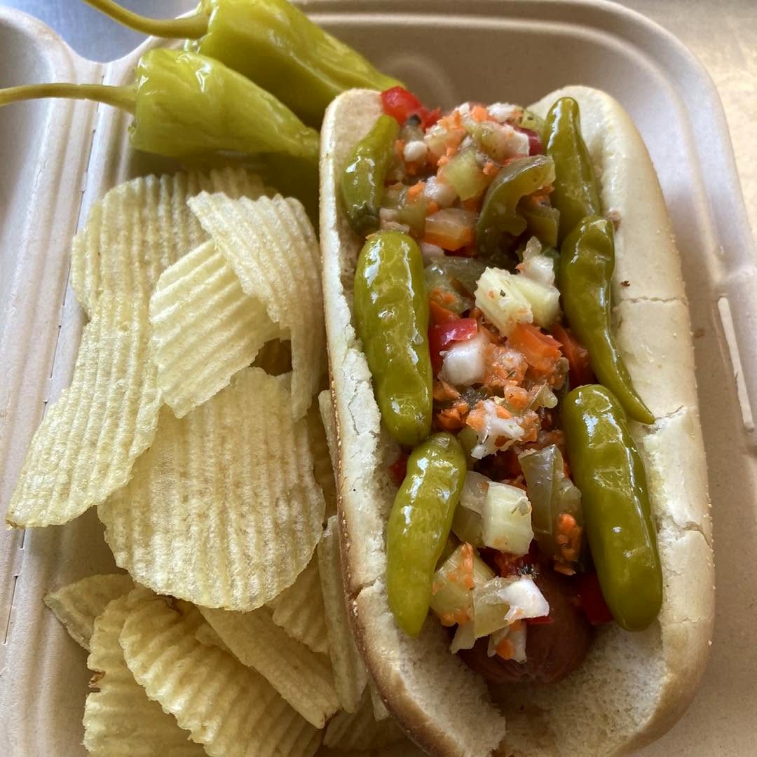 Chicago-style hot dog topped with giardiniera and sport peppers