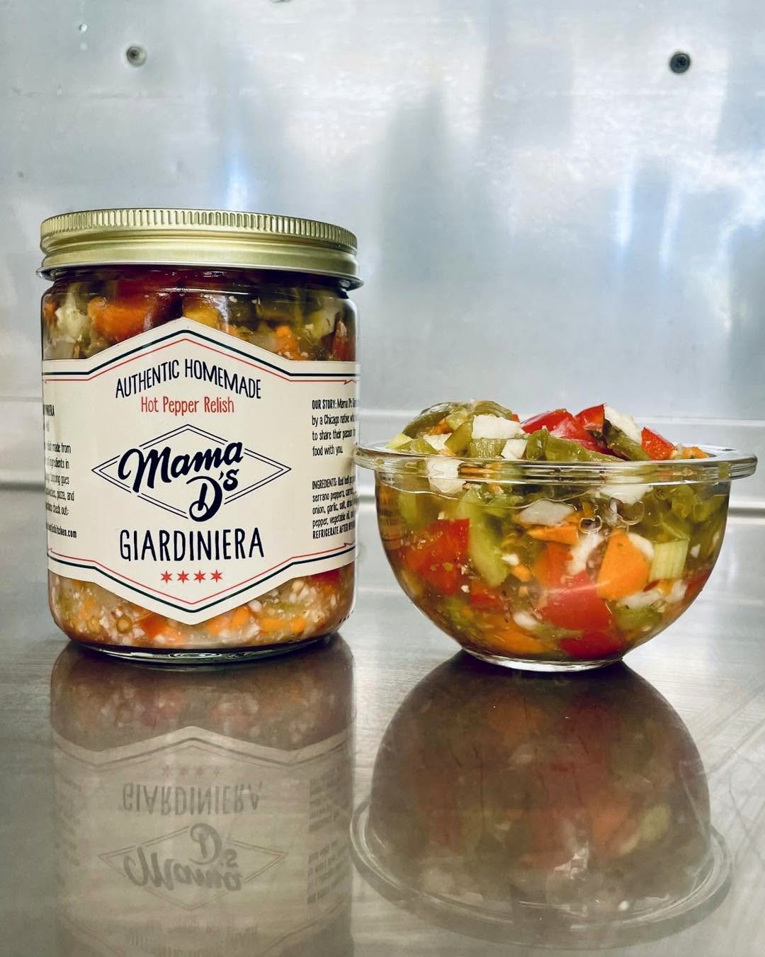 A jar of Mama D's Giardiniera alongside a glass bowl of the hot pepper relish