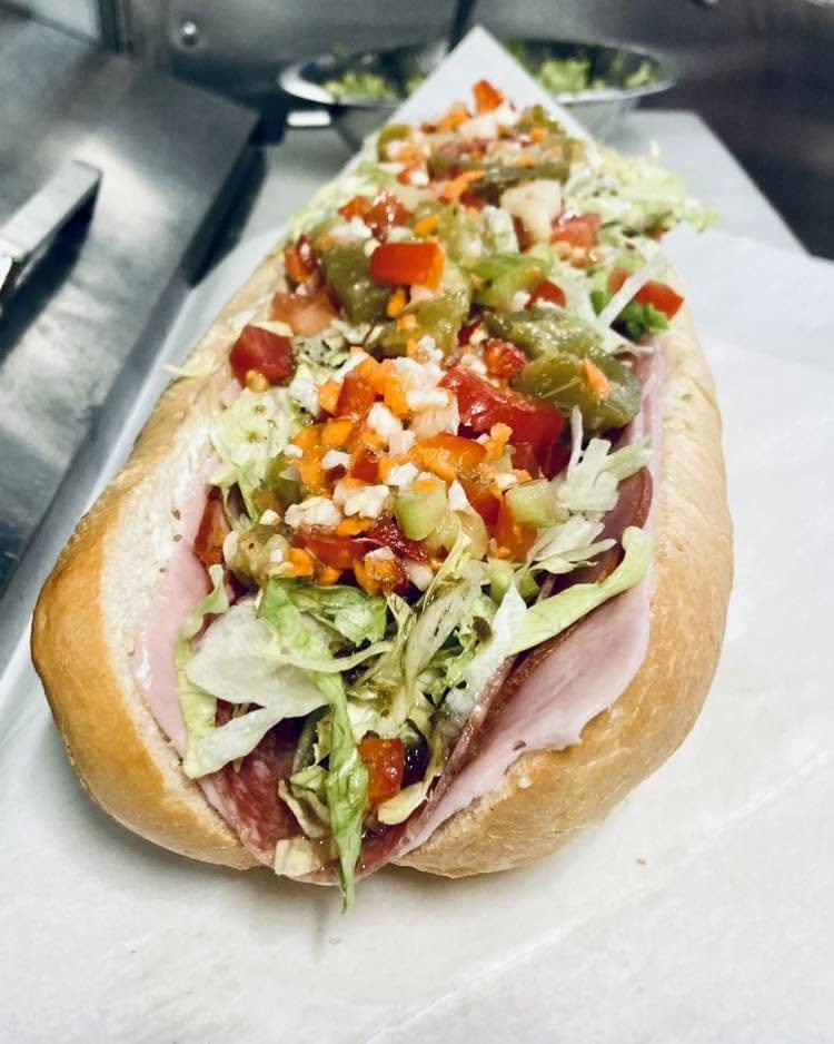 Sub sandwich piled with giardiniera, lettuce and peppers